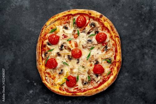 tasty italian pizza with mozzarella cheese, mushrooms, tomato, bell pepper, onion on a stone background