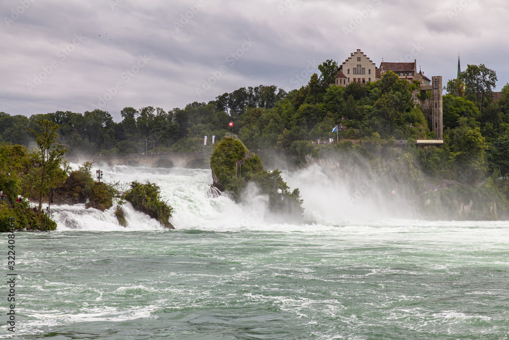 Stunning panorama view of the Rhine Falls, the most powerful waterfall in Europe on the High Rhine river, on a cloudy summer day with Laufen Castle in background, Schaffhausen, Switzerland