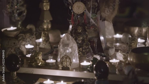 Close up of Feng Shui altar at home in living room on the table. Art. Attracting wealth and prosperity concept, rystal clusters, golden Buddah figure and candles. photo