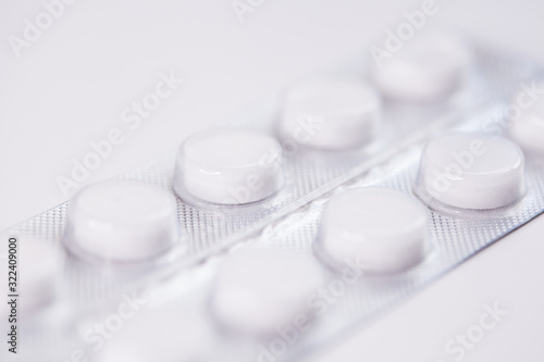 Close up of white tablets, pills in blister pack, medications drugs, macro, selective focus