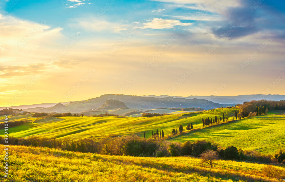 Volterra panorama, rolling hills, green fields and white road. Tuscany, Italy