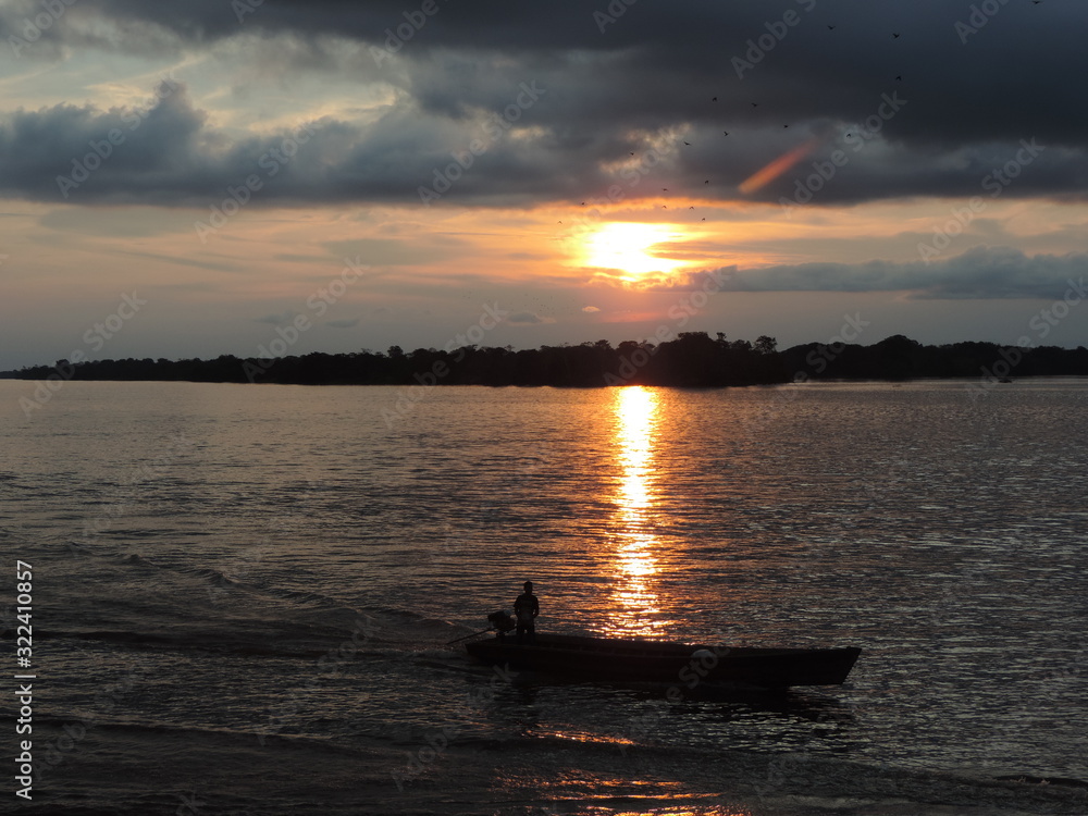 canoe in ria in amazonia in the background the sunset
