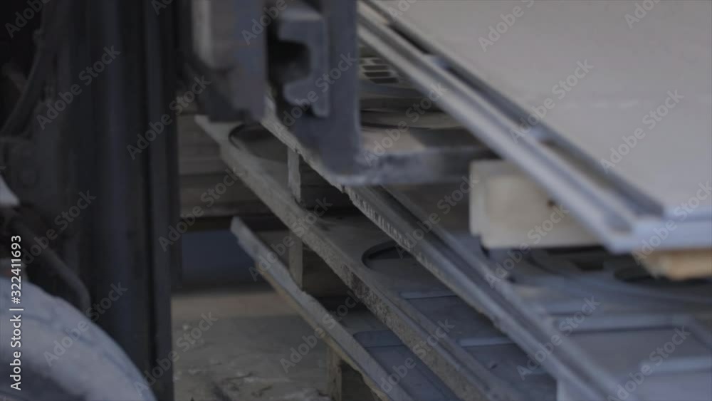 Electric forklift move away a pallet with iron on it. Close up shot Electric forklift move away a pallet with iron on it. Close up shot
