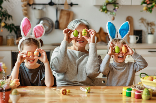 Happy easter! family   grandmother and children grandchildren paint eggs for holiday. photo