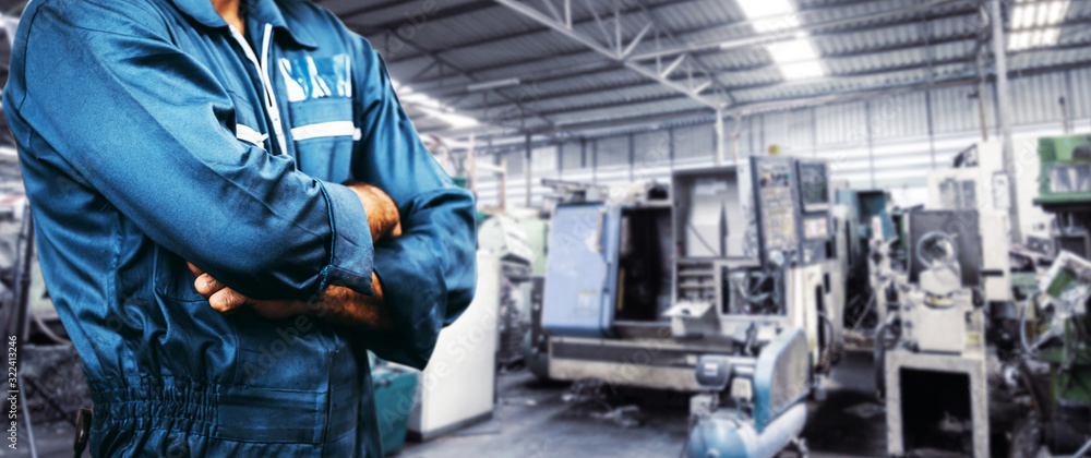 The image Engineer is wearing a uniform safety for industry background. men is standing with arms folded in a storage facility or warehouse. The image Engineer is wearing a uniform safety for industry background. men is standing with arms folded in a storage facility or warehouse.