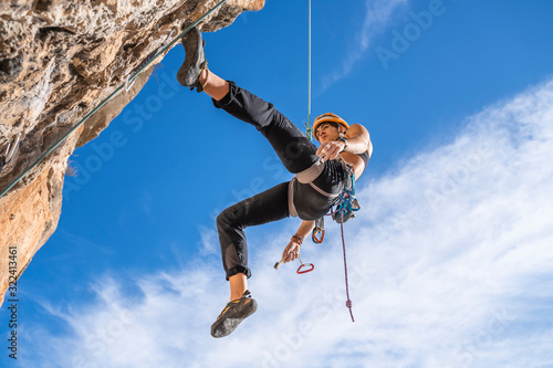 Female climber abseiling from rock face