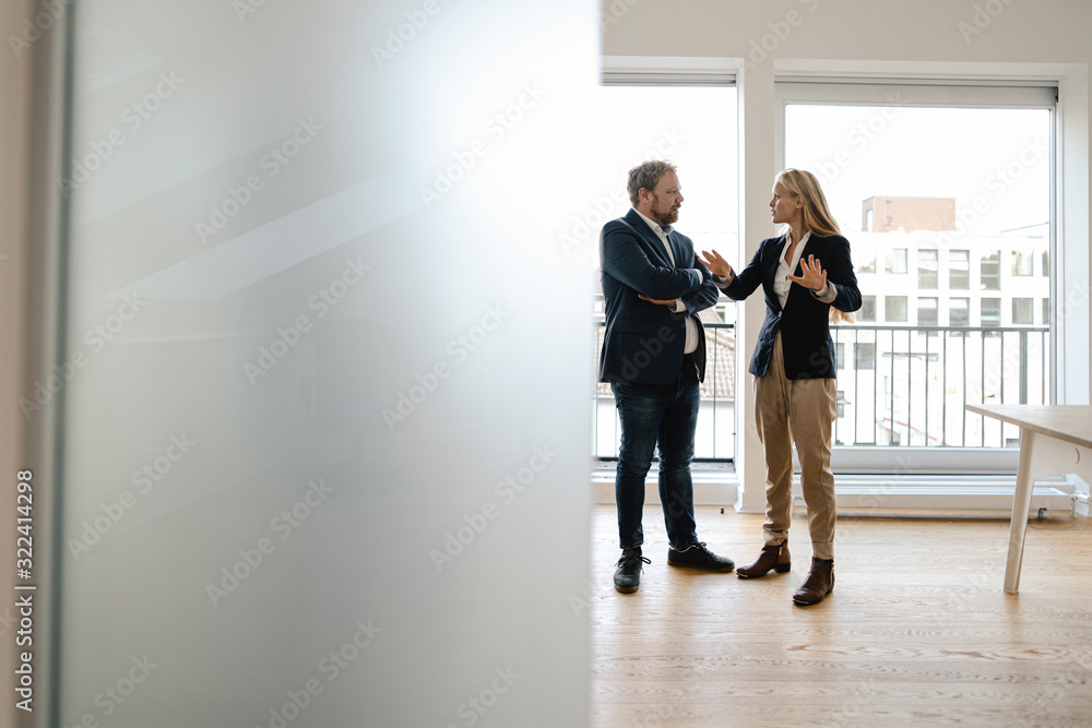 Businessman and businesswoman talking in office