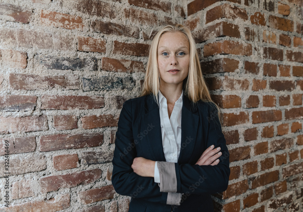 Portrait of a confident young businesswoman at a brick wall Portrait of a confident young businesswoman at a brick wall