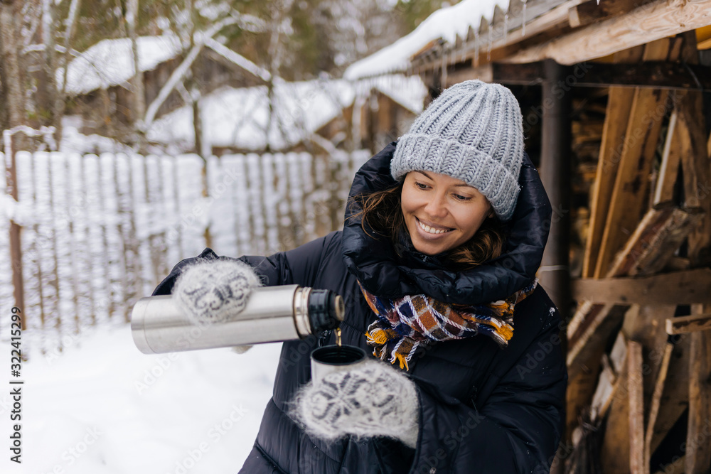 Portrait of happy woman using thermo flask in winter Portrait of happy woman using thermo flask in winter