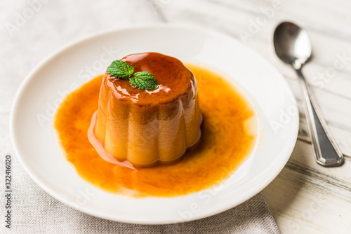 Εκτύπωση καμβά Close up of a flan creme caramel pudding with mint, a custard dessert against wh