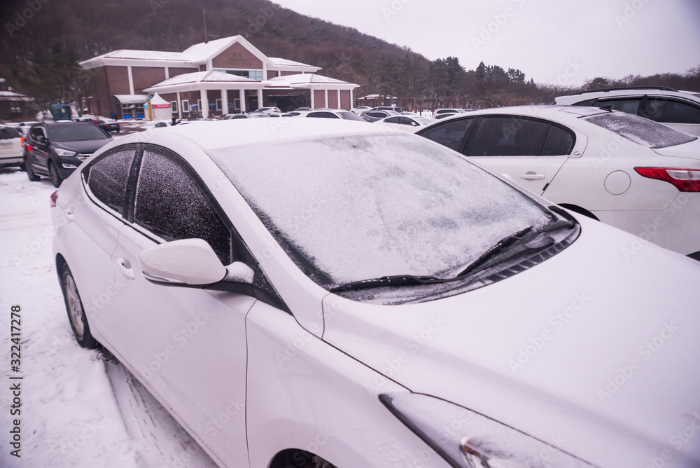The car's roof is covered with snow white.Extremely cold, winter travel atmosphere, winter travel concept