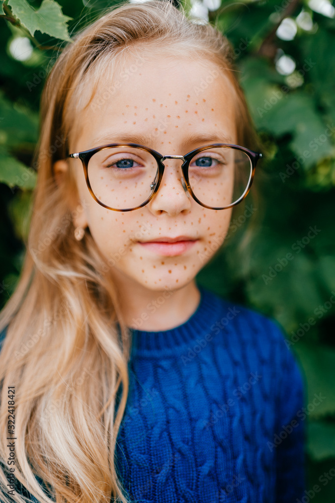 Portrait of young beautiful girl stands in the garden and smiles Portrait of young beautiful girl stands in the garden and smiles
