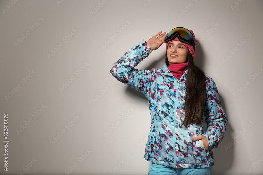 Woman wearing stylish winter sport clothes on light grey background, space for text Woman wearing stylish winter sport clothes on light grey background, space for text