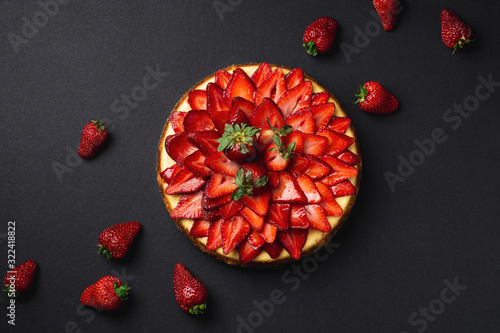 Strawberry Cheesecake top view from above. A classic decadent dessert, this sweet and delicious homemade baked cheesecake is topped with fresh strawberry slices. The perfect cake for a birthday!