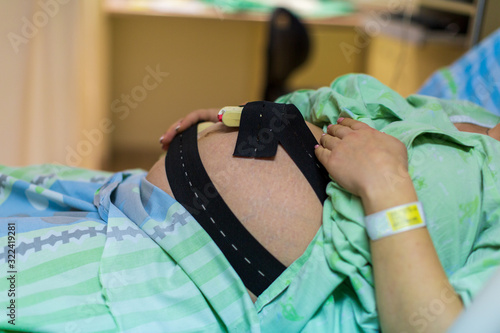 Pregnant woman in hospital with cardiotocography bell photo