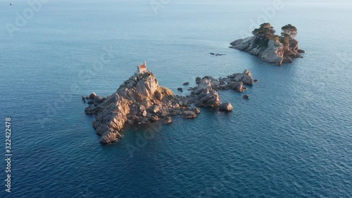 Two islets (Katic and Sveta Nedjelja - Saint Sunday) off Petrovac Montengro, on the coast of the Adriatic sea. Aerial footage. photo