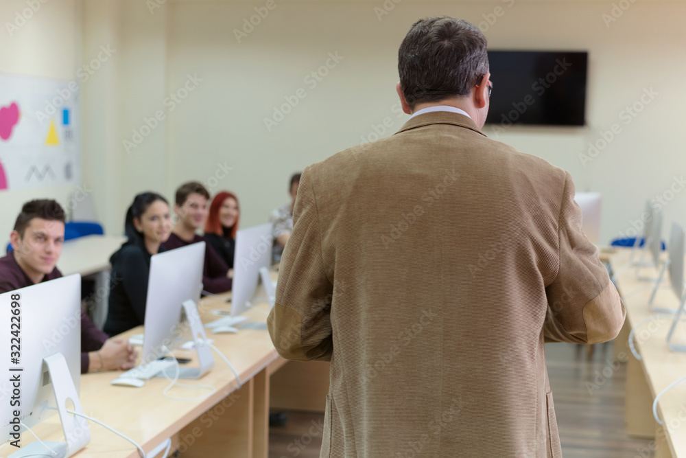 Obraz premium IT technologies teacher at work. IT professor explain lesson to multietchnic students. Professor's hand with gesture.