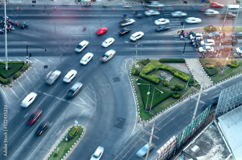 The view from above, cars and motorcycles are blurred, traveling on the highways, intersections commonly seen in the city.