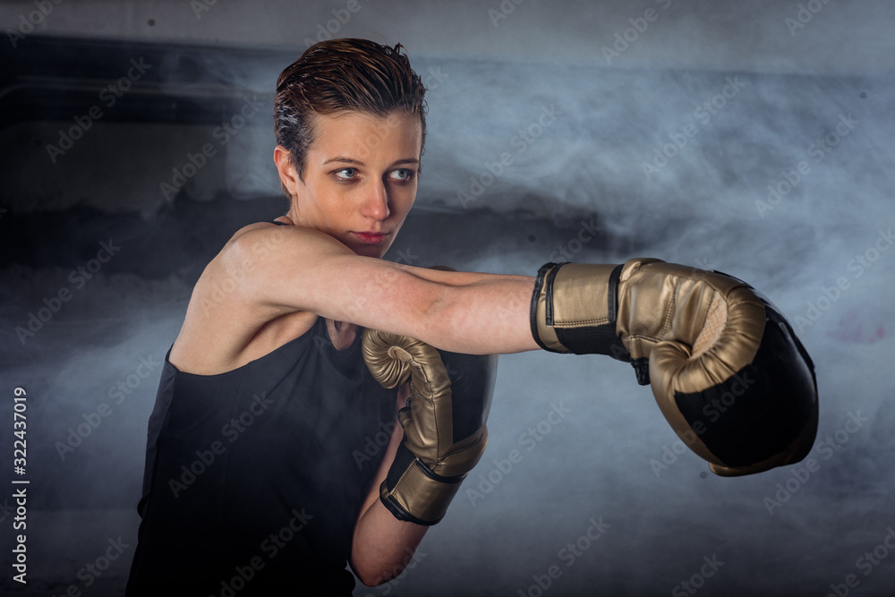 Closeup image of a female boxer practicing punching with boxing gloves