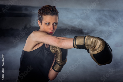 Closeup image of a female boxer practicing punching with boxing gloves © qunica.com