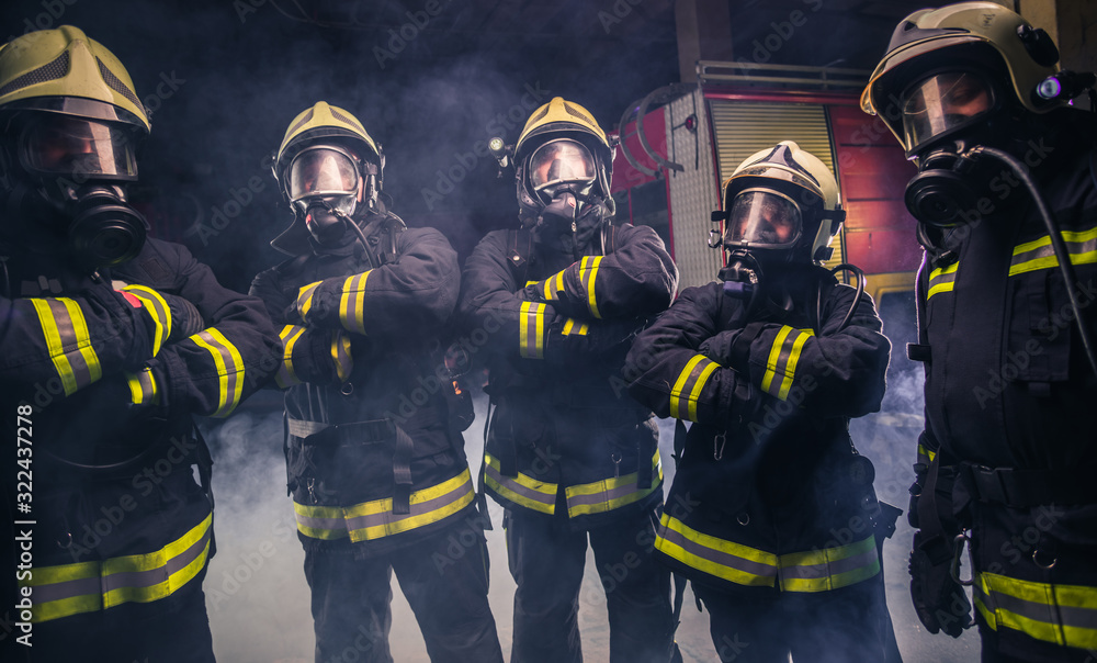 Fototapeta premium Team of fireman standing the middle of the fire extinguisher's smoke inside the fire department