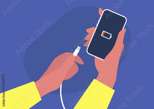 Hands holding a phone and a charger, low battery, white cable, new technologies