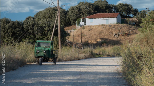 Green 3 wheeled vehicle parked on the side of the road photo