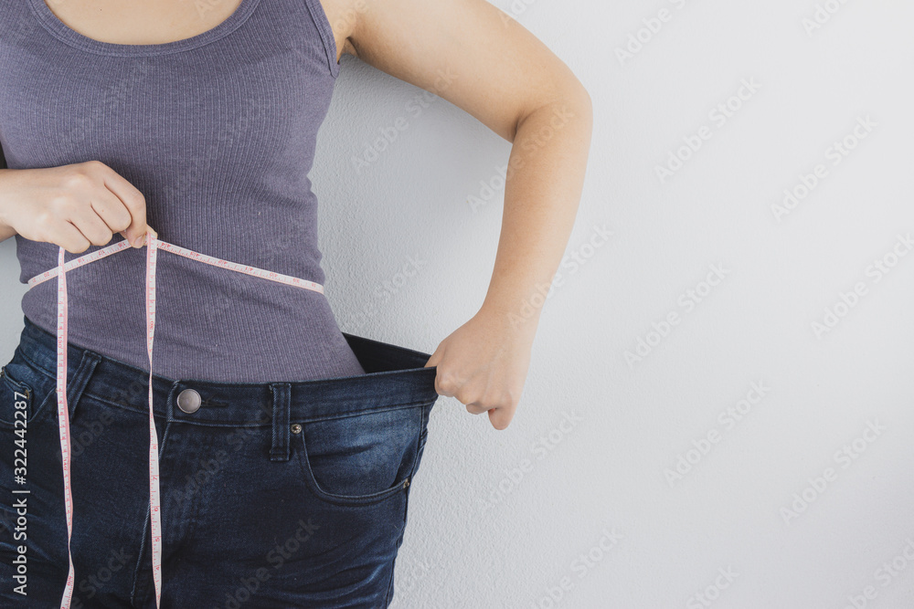 Φωτογραφία Close up shot of woman with slim body measuring her waistline and torso