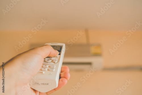 Hand holding remote control air conditioner