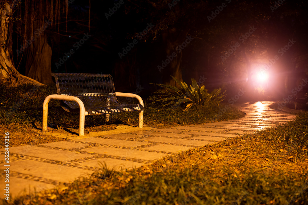 Bench under street lamp in night park