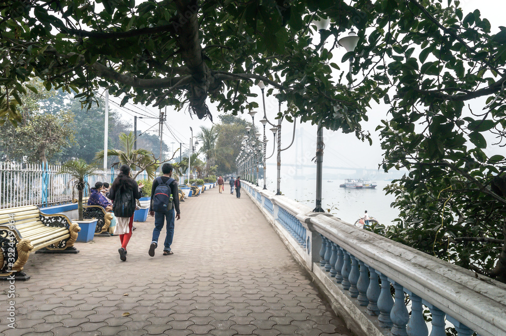Beautiful Ganges riverside promenade paved Public Park in riverfront built for leisurely walk. Millennium Eco Tourism Recreational area on quiet relaxed evening sundown. Kolkata India January 2020