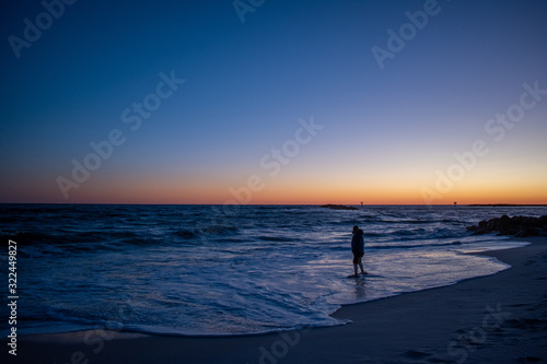 Man testing ocean waters sunrise sunset