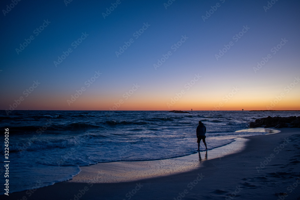 Man testing ocean waters sunrise sunset