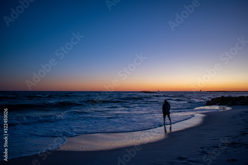 Man testing ocean waters sunrise sunset