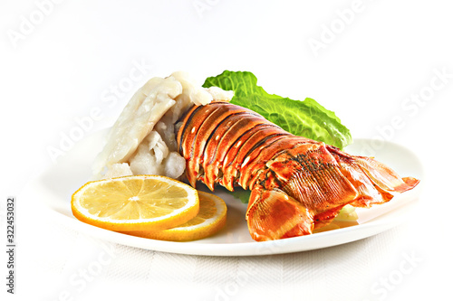 Grilled lobster tail served on a white plate isolated on white, shallow focus