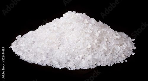 Pile of sea salt isolated on black background.