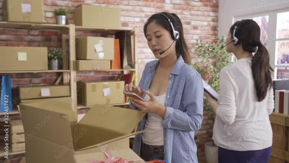 two online shopping company female operator women in headsets working in modern office. girl cusotmer support talking with client through internet to solving problem checking order on mobile phone. two online shopping company female operator women in headsets working in modern office. girl cusotmer support talking with client through internet to solving problem checking order on mobile phone.