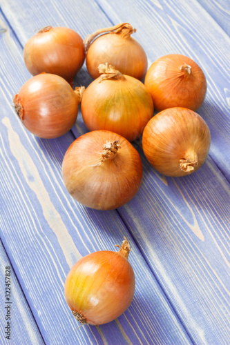 Fresh onions lying on purple boards, healthy nutrition concept