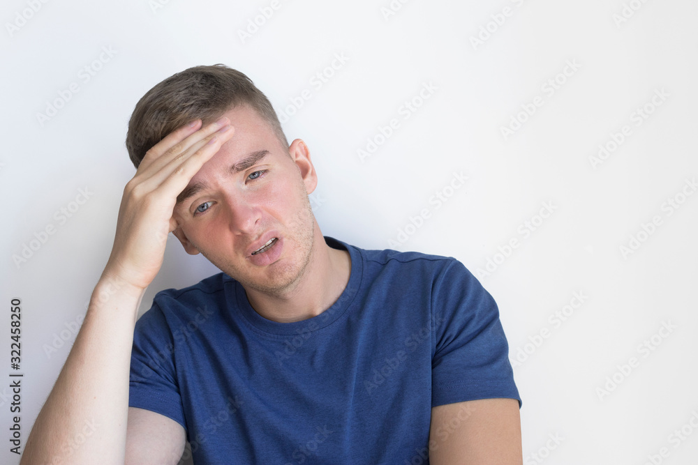 Sick young man, ill guy is suffering from headache, fever. Tired exhausted person holds his head, forehead with hand. Bad, negative feeling of despair, apathy. Fatigue from life, lots of problems Sick young man, ill guy is suffering from headache, fever. Tired exhausted person holds his head, forehead with hand. Bad, negative feeling of despair, apathy. Fatigue from life, lots of problems