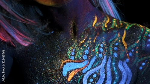 Closeup of Female Collarbone. Sensual Girl with Ultraviolet Paints on Chest and Hands. Colourful Vivid UV Pigment Shining in a Dark. Concept of Modern Body Art and UV Make Up Technique.