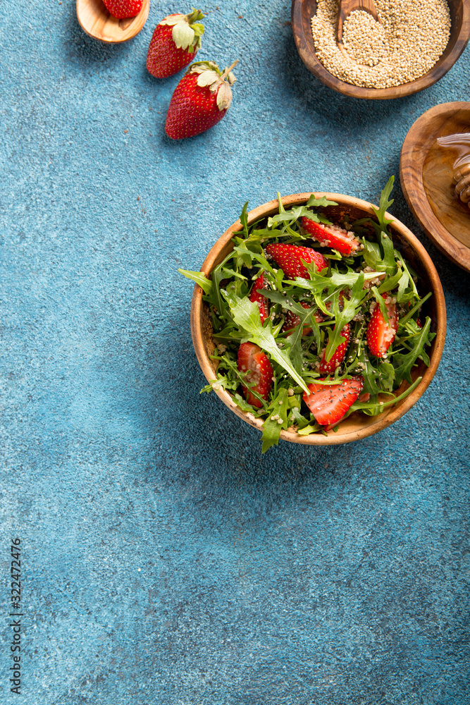 Arugula salad with quinoa on blue concrete table. Dietary food.