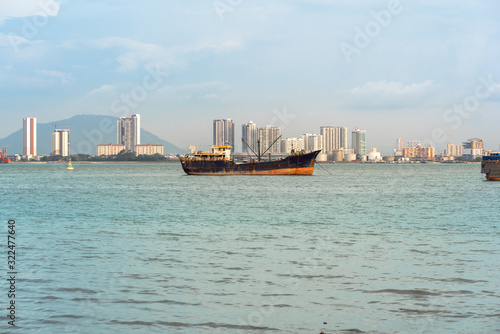 Moored merchant ship in front of the city Butterworth also known as Bagan on the mainland of the Malaysian state of Penang  © ksl