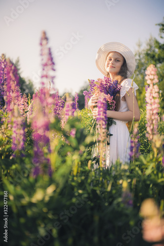 Lovely girl in a white dress in a field of flowers