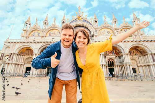 young pretty couple posing in front of saint marks basilica venice italy photo