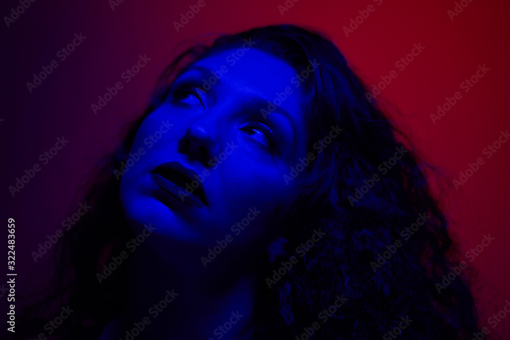 Young woman looking up in studio, close-up