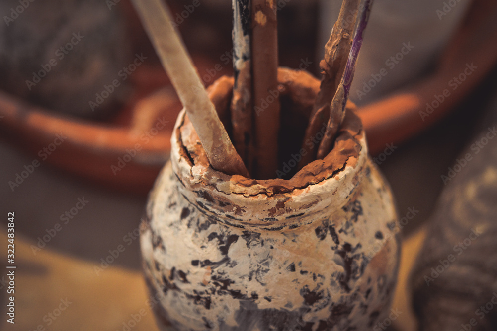 A glass stained with smeared clay with tassels A glass stained with smeared clay with tassels