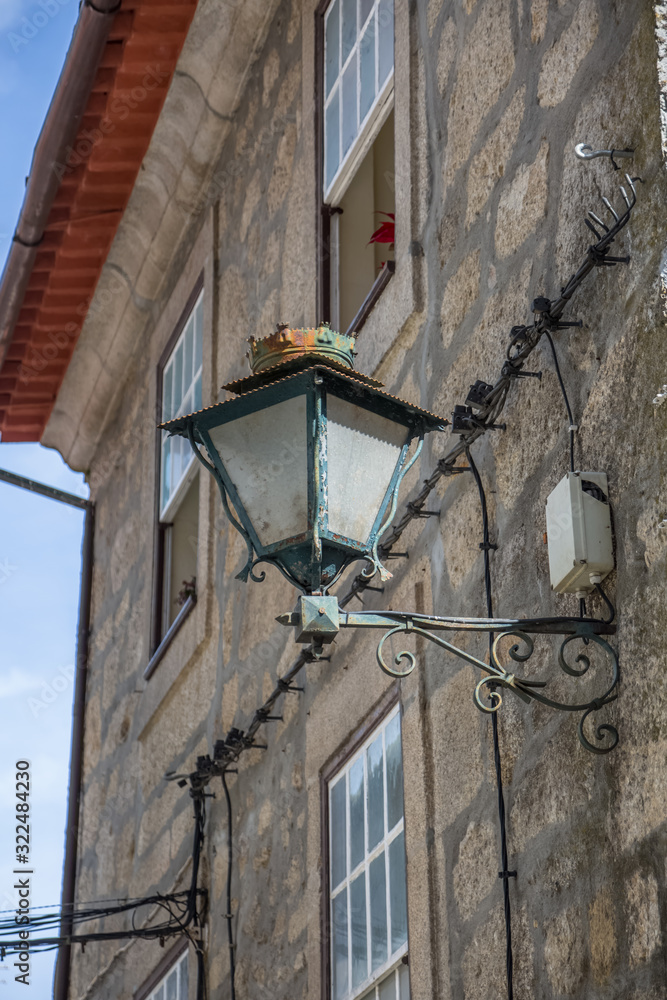 Detailed view of old stone facade with street retro wall lamp, on metal material