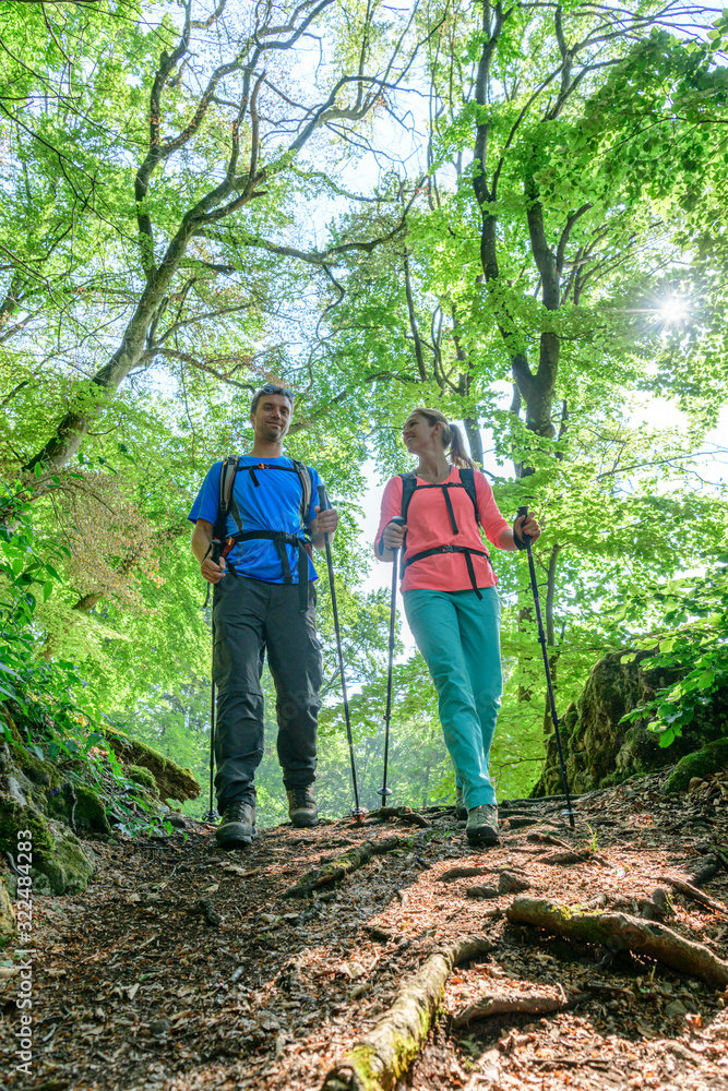 Junges Paar mit Hund beim Wandern im felsigen Wald Junges Paar mit Hund beim Wandern im felsigen Wald