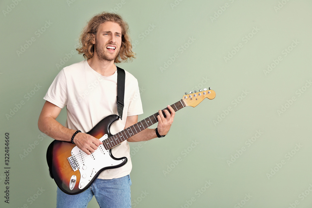 Obraz premium Man playing guitar on color background