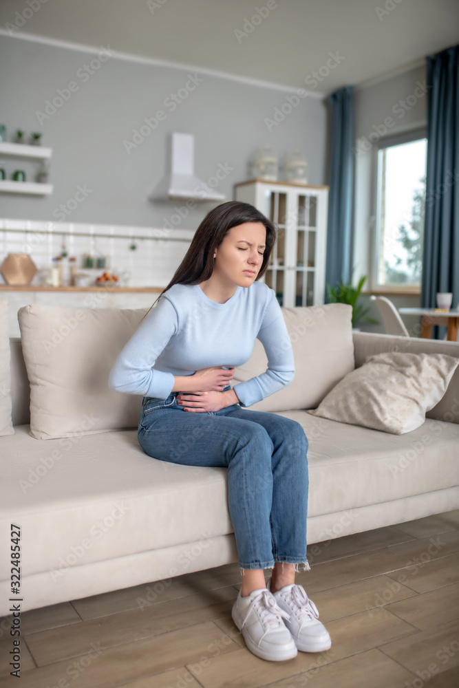 Young woman having a strong shomach ache Young woman having a strong shomach ache